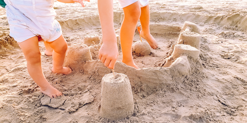 Kinder beim Sandburg bauen